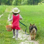 Little girl with dog walks on the road