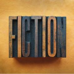 A wood cut-out of an ink stamp reads "fiction."