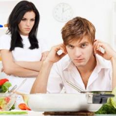 Man sits in kitchen plugging his ears while his angry wife glares