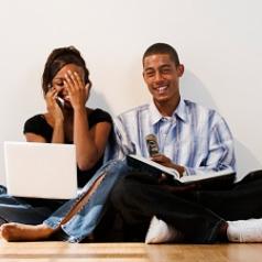 Happy couple with laptop and book