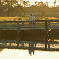 Couple walking over a bridge at sunset