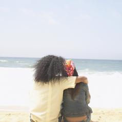 Rear view of couple hugging on beach
