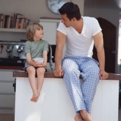 Father and son sitting on kitchen counter