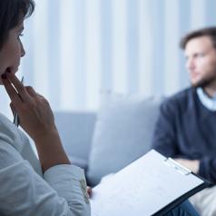 Therapist looks at person in treatment thoughtfully
