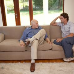 Father and son talking on sofa