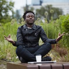 Man sitting near bench at a park, meditating