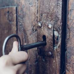 A hand turning a key to unlock a door