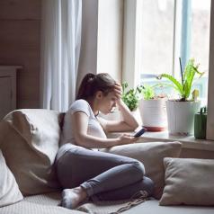 Young woman on her phone alone at home