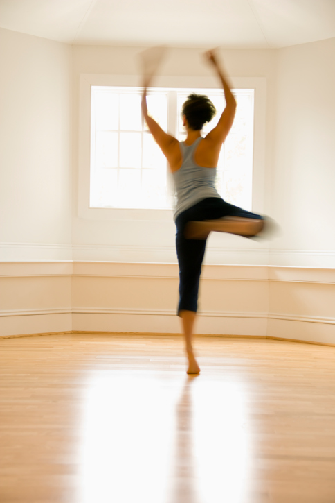 A dancing woman in a sunlit studio