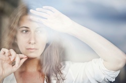 A distressed woman looks out the window