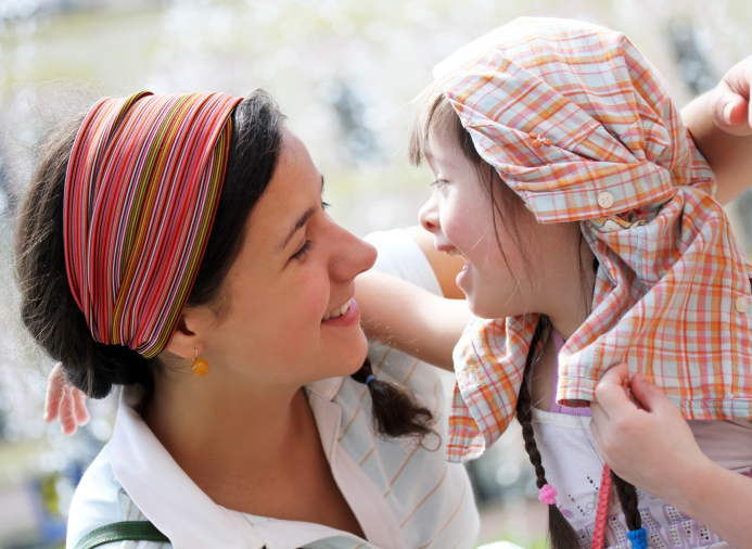 A young girl and her mother smiling at each other