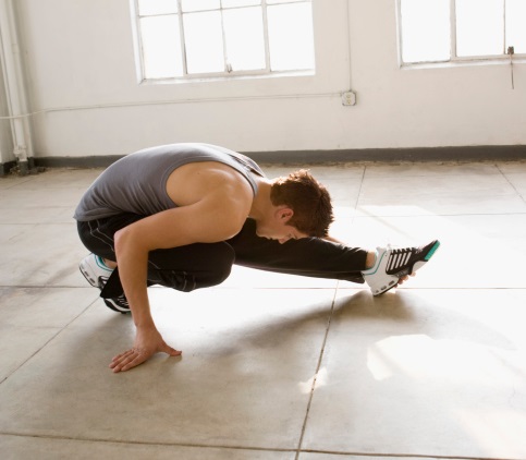 Male dancer stretches on floor