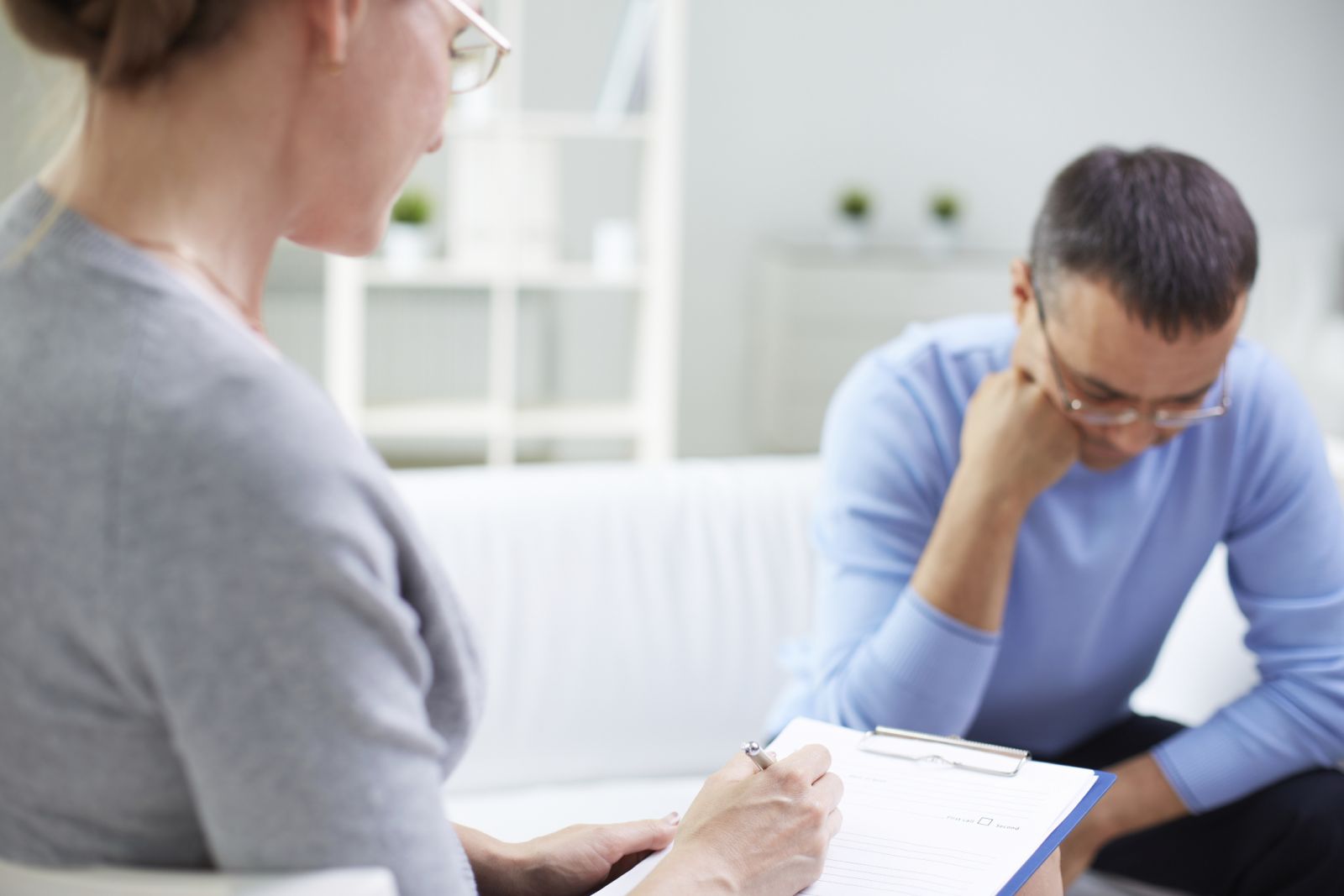 A man in therapy looks down at the floor