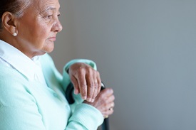 A pensive, elderly woman gazes down