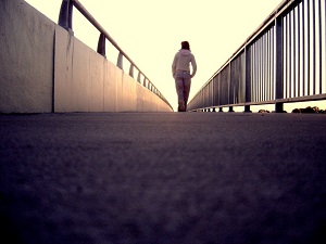 A person walks away, across a bridge