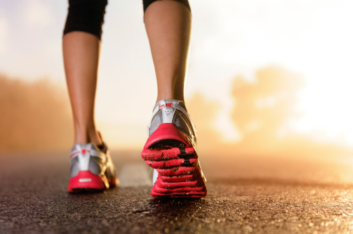 A runner's feet on the pavement at dawn