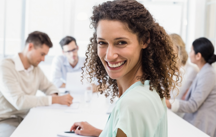 Woman in meeting smiling at camera