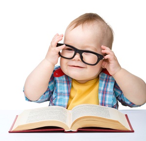 A baby wearing glasses pretending to read