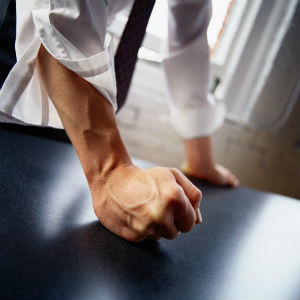 man pounding fist on table