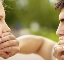 Man and woman covering each others' mouths