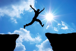 A man jumps from rock to rock.