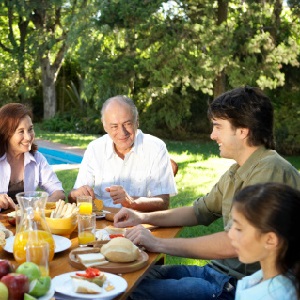 A family eats breakfast outside.