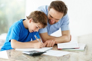 A man helps his son with homework. 
