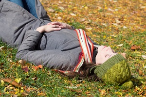 A woman lies in the grass, looking serene.