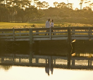 Couple walking over a bridge at sunset