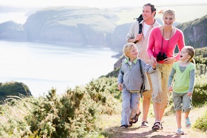A family hikes over a bluff. 