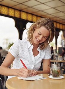 A woman writes in a cafe.