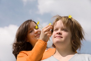 Girl putting flowers in friend's hair