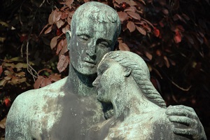 A statue of a man and a woman are in an affectionate pose.