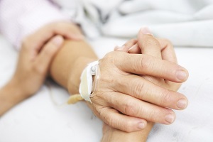 Two people holding hands in hospital