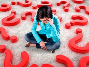 Woman sitting surrounded by question marks