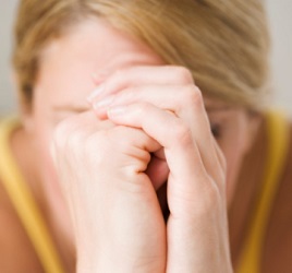 A woman rests her head on her hands