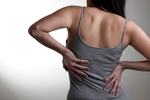 Woman rubbing her own back
