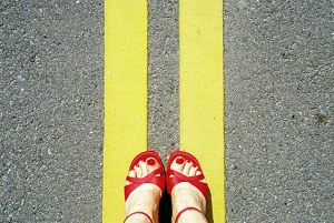 Women's feet standing on road