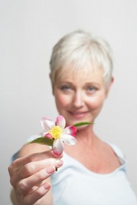 Older woman holding out flower