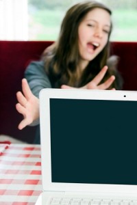 Woman reaches for a laptop