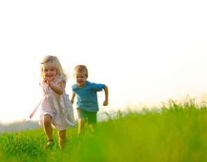 Young siblings running in field