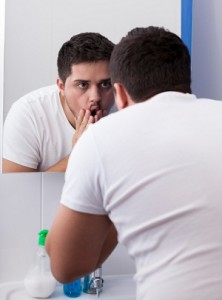 Stressed looking man in bathroom mirror