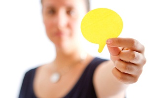 Woman holding cut out speech bubble