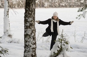 A happy woman runs through snow.