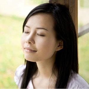 A woman closes her eyes and takes a moment to breathe.