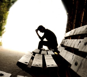 Profile of a sad person on bench