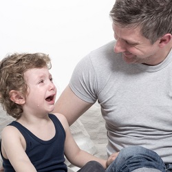 Father consoles crying boy