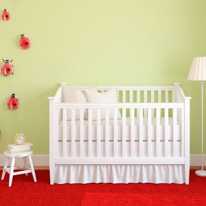 A decorated baby's room has an empty crib in the center.