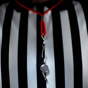 A close-up picture shows a whistle hanging around a referee's neck.