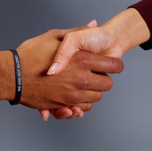 Hand shaking, one wearing bracelet